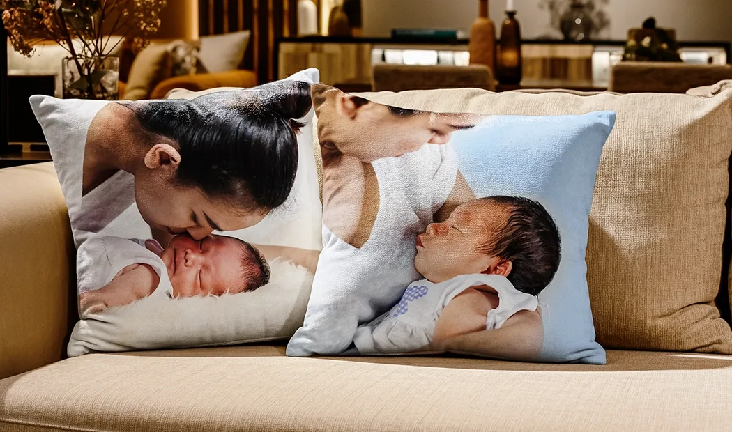 Oreiller personnalisé avec photo de famille : un couple heureux câlinant leur bébé, imprimé sur un coussin blanc posé sur un canapé vert.