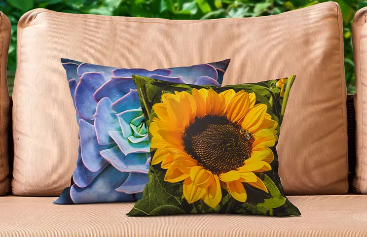 Coussins personnalisés : un succulent bleu et un tournesol vibrant ornent un canapé extérieur.