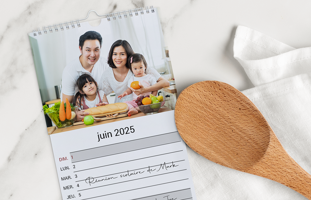 Calendrier mural personnalisé juin 2025 : photo familiale joyeuse et notes manuscrites.
